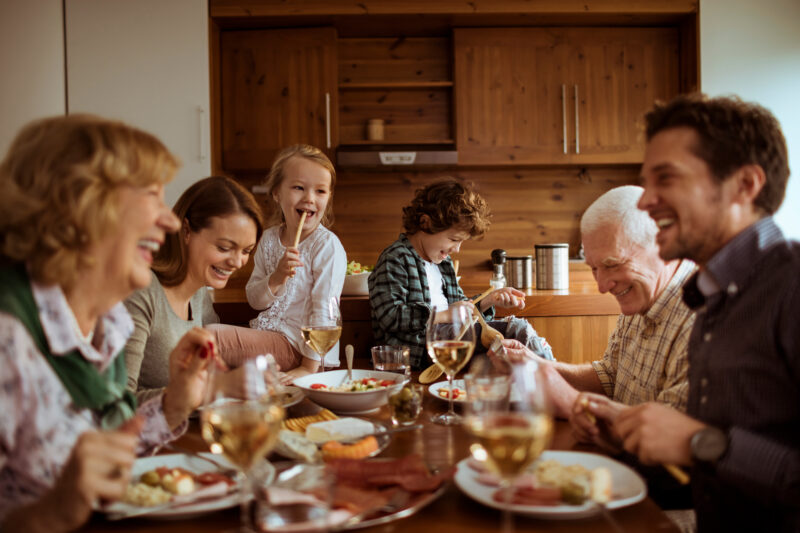 Familjen njuter av middagen tillsammans i ett skönt tempererat hem.