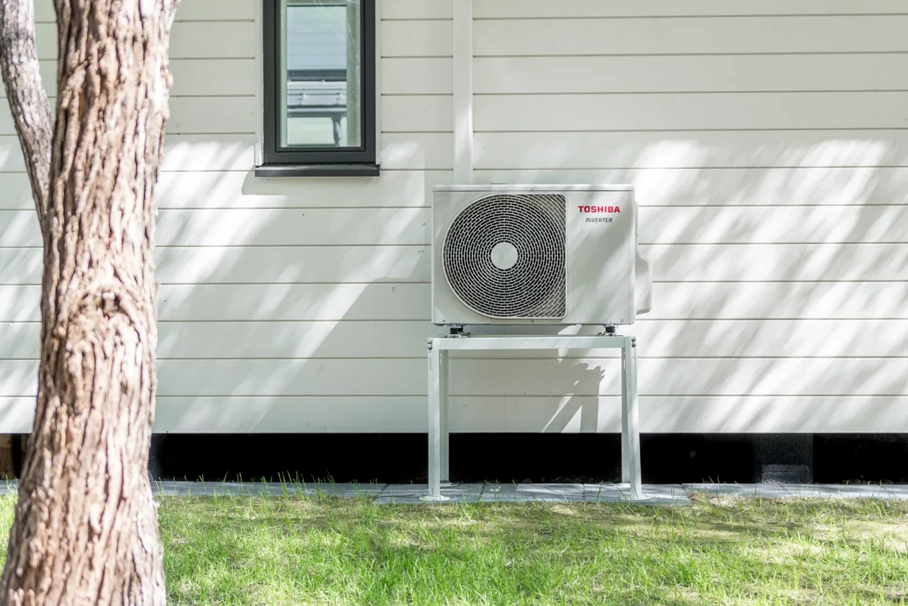 Toshiba luftvärmepump installerad på ytterväggen till ett garage.